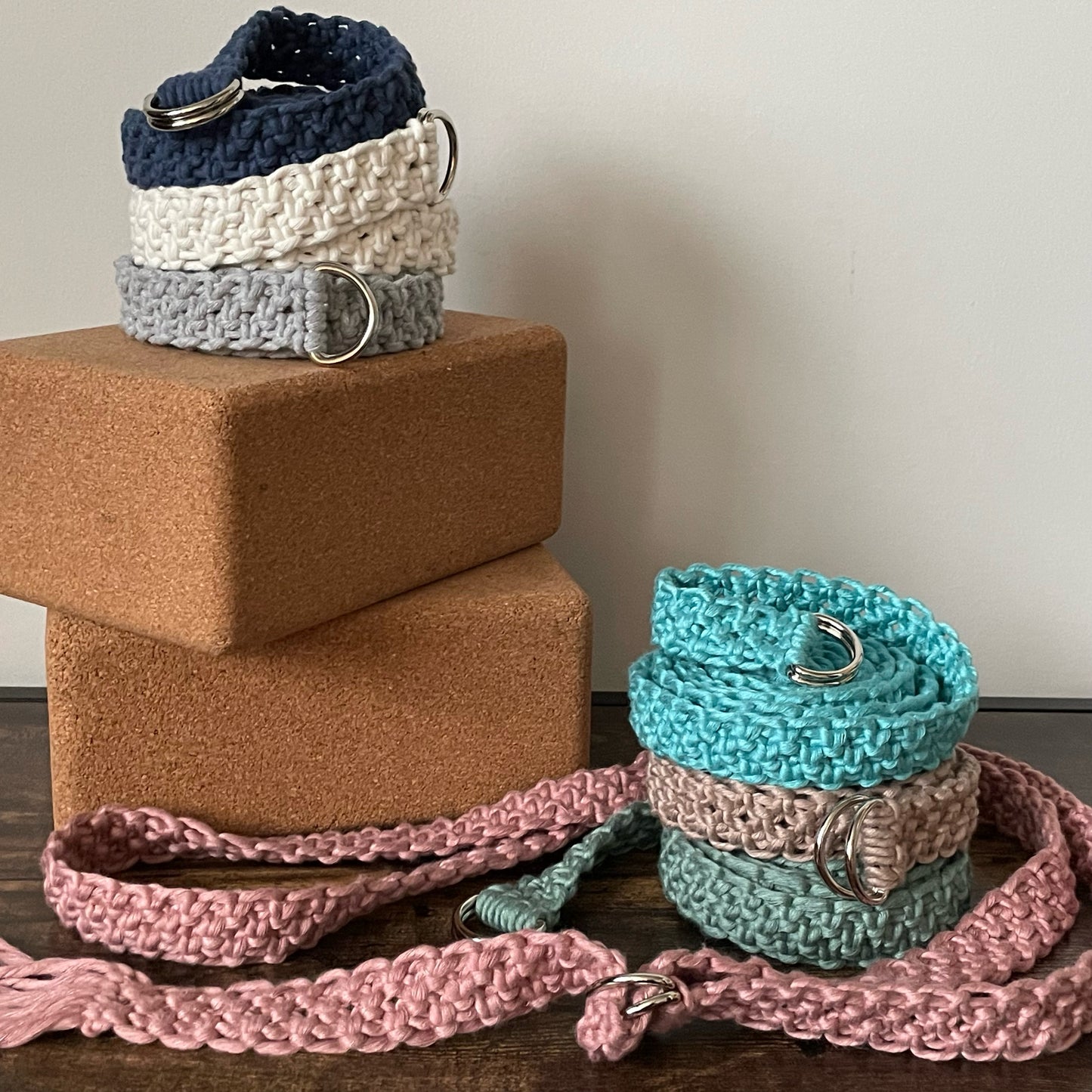 Adjustable Macramé Yoga Straps in Bright Bamboo colors, stacked on yoga blocks, light background