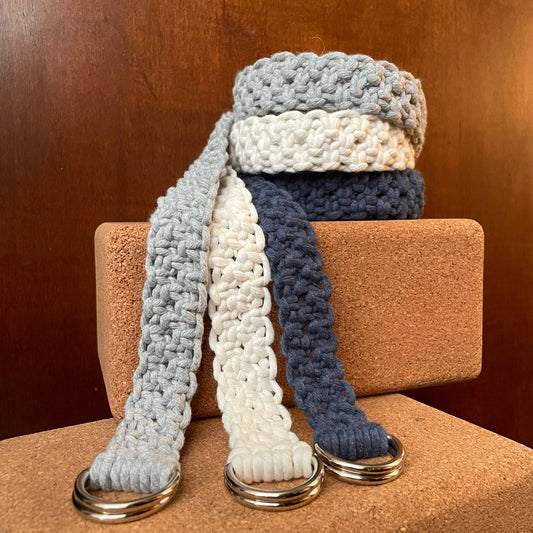 Adjustable Macramé Yoga Strap Prop in Cool Cotton colors, stacked on yoga blocks, dark bakground