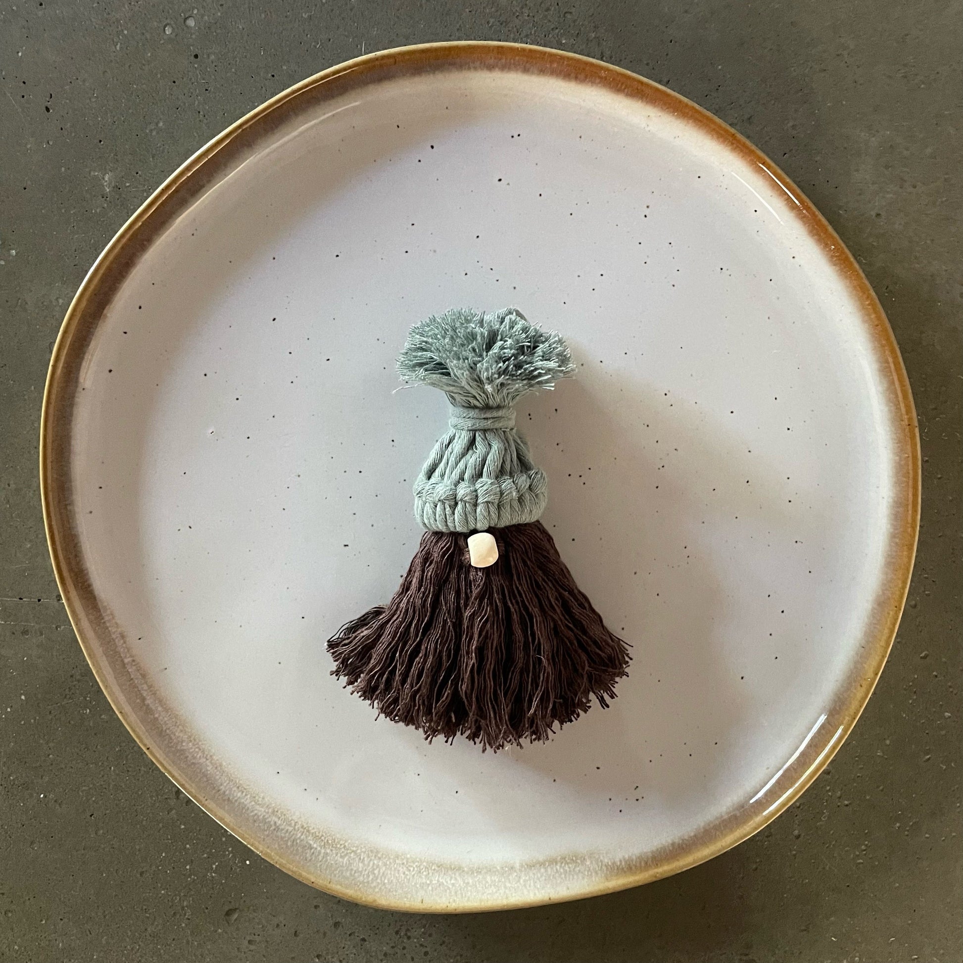Gnome, laurel green hat, beige nose, chocolate wavy beard, centered on dinner plate