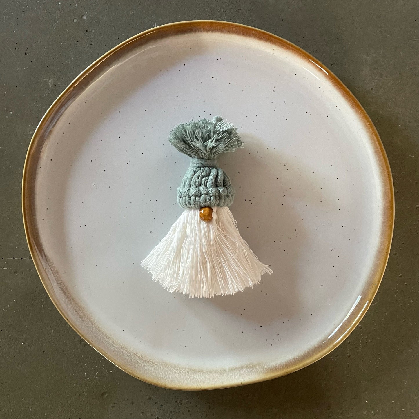 Gnome, laurel green hat, light coffee nose, off-white combed beard, centered on dinner plate