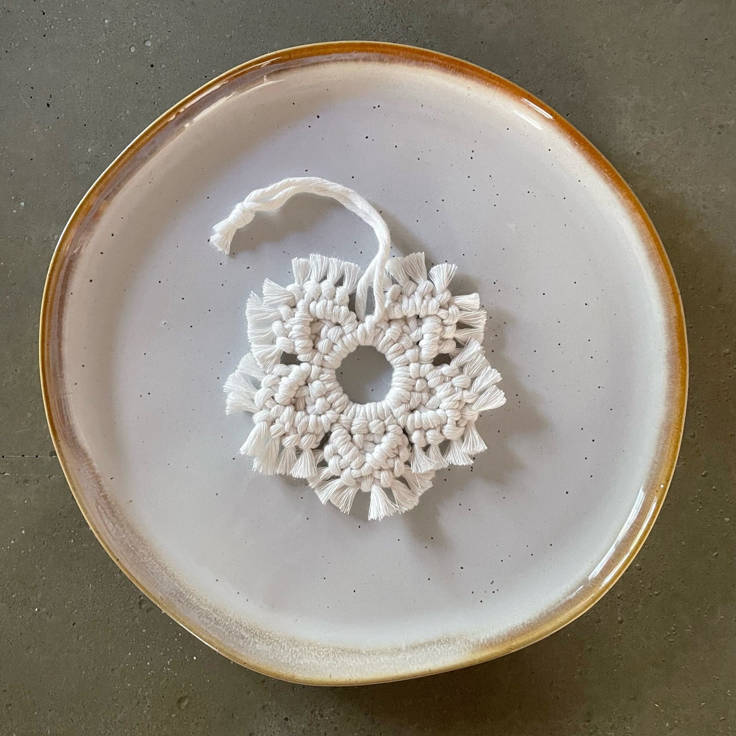 Off-White Snowflake Ornament centered on dinner plate