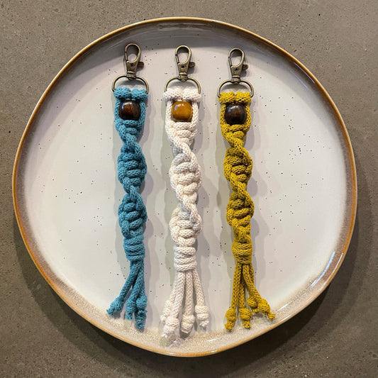 3 Key Chains centered on dinner plate. Twisted style in 3 colors: Teal, Natural White, Spicy Mustard.